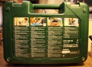 Zu sehen ist die Rückseite eines Koffers, des Elektrowerkzeugs Bosch PEX 300 AE. Darauf befinden sich vier Spalten. Dort befinden sich vier Punkte mit Beschreibung. Diese sind in 32 Sprachen aufgeführt.