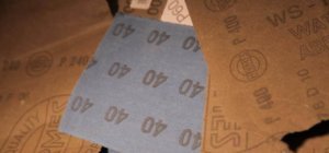 Schleifpapier liegt kreuz und Quer herum. Es sind immer die Rückseiten zu sehen. Dadurch sind die Stärken der Körnungen ersichtlich. 40, 60, 240, 1000 sind zu sehen. Auch der Name Hermes ist erahnbar.