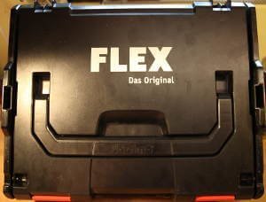 Eine schwarze Oberfläche des Flex Koffers. Die vier Buchstaben stehen in weißer Schrift genau mittig. rechts darunter die Worte 'Das original'.